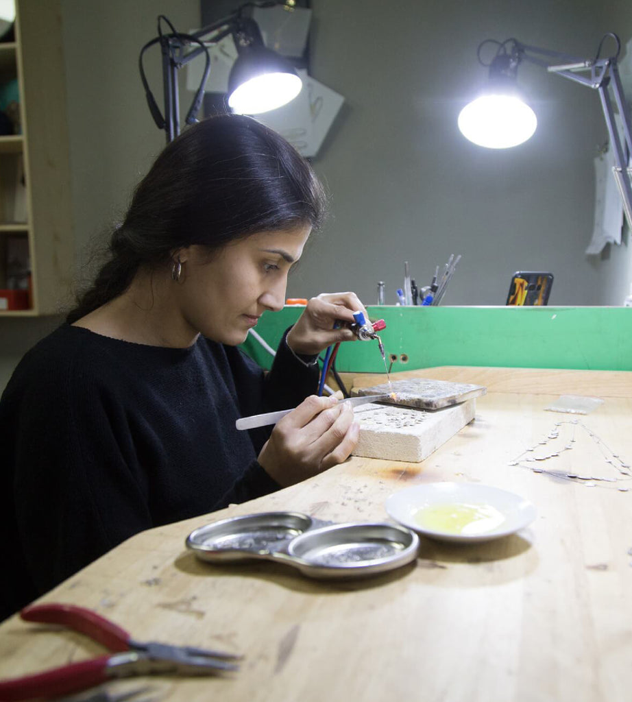 Person using tools in workshop to craft Narrow Cable Bracelet with Lapis Lazuli Gemstone